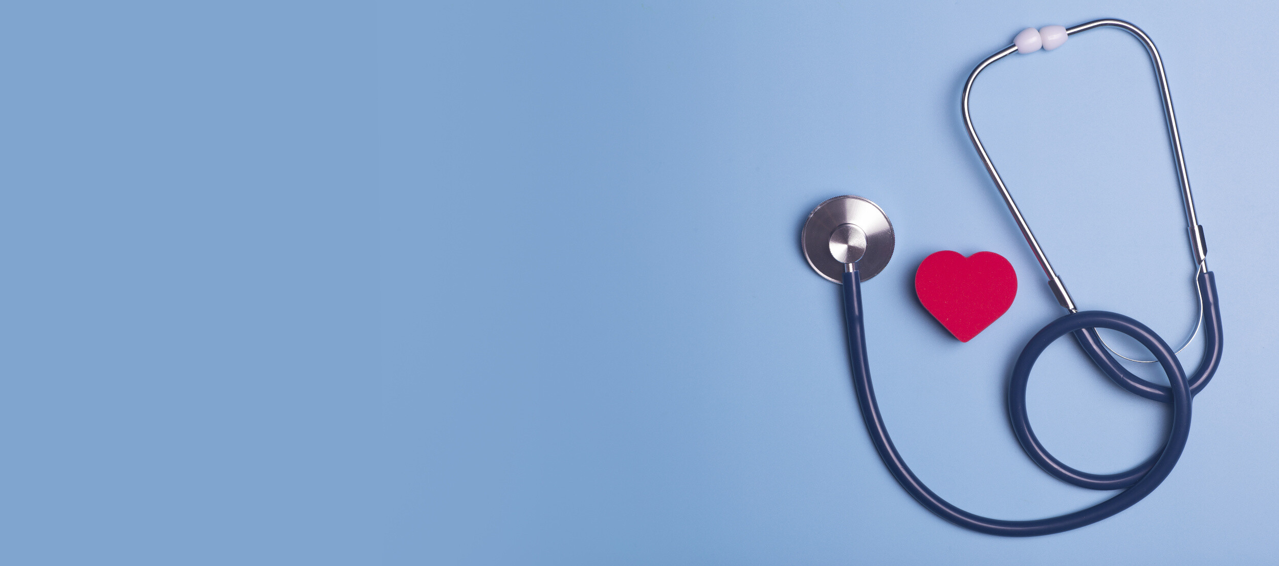 Stetoskop und ein rotes Herz auf blauem Hintergrund